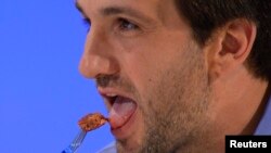 Josh Schonwald, a U.S.-based food writer, tastes the world's first lab-grown beef burger during a launch event in west London in August.