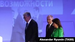ყაზახეთის პრეხიდენტი ყასიმ ჟომართ ტოყაევი, რუსეთის პრეზიდენტი ვლადიმირ პუტინი და Russia Today-ის მთ. რედაქტორი მარგარიტა სიმონიანი