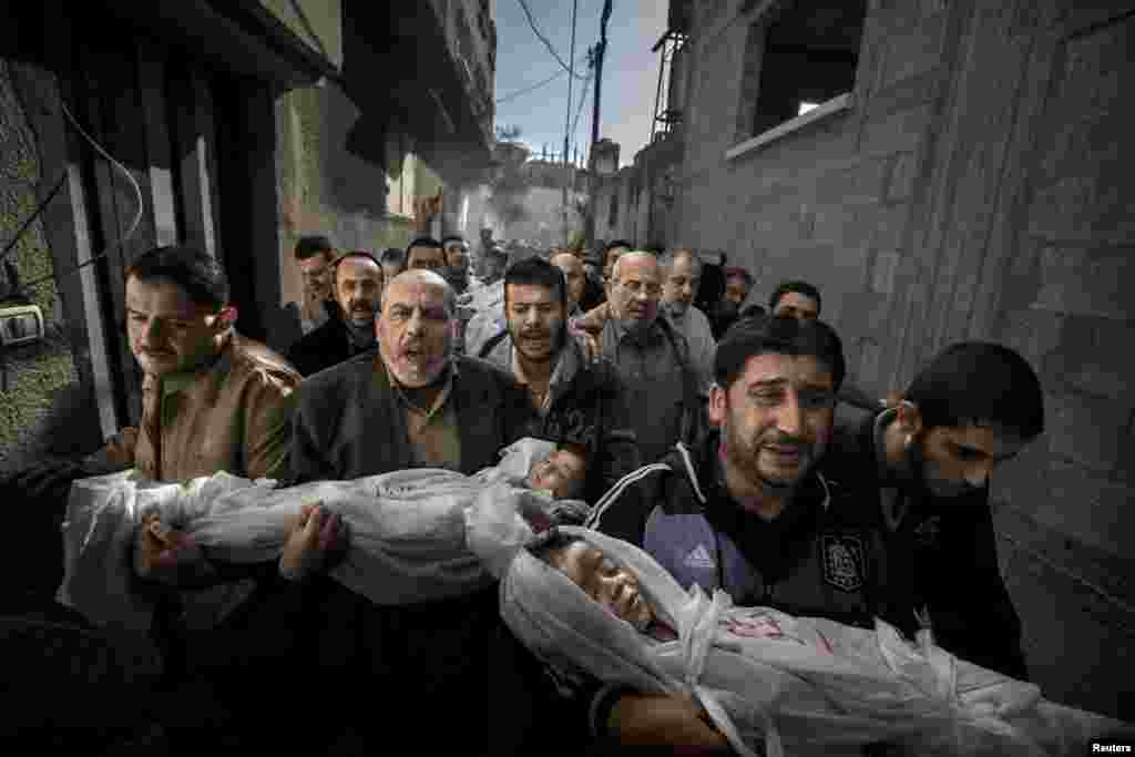 Победитель фотоконкурса World Press Photo 2013 в категории «Фотография года». Газа. Двухлетняя Сухаиб Хиджази и её трёхлетний брат Мухаммад погибли, когда в их дом попал израильский снаряд. Их отец Фуад также погиб, а мать попала в отделение интенсивной терапии. Брат Фуада несёт тела детей к мечети, где пройдут похороны. (Paul Hansen/Sweeden/Dagens Nyheter)