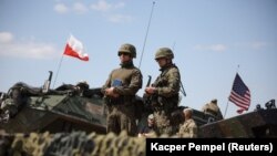 POLAND - Polish and American soldiers stand during Defender Europe 2022 military exercise of NATO troops at the military range in Bemowo Piskie, May 24, 2022.
