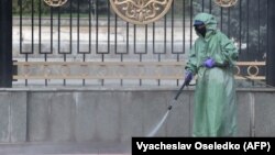Ак үйдүн тегерегин дезинфекциялап жаткан адам. Бишкек. 26-март, 2020-жыл. 