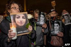 Demonstranti u Varšavi sa natpisom "Ni jedna više" i fotografijama trudne Poljakinje Ize koja je preminula, povodom godišnjice presude Ustavnog suda kojom je skoro potpuno zabranjen abortus 6. novembra 2021.