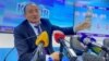 Глава Минздрава Алымкадыр Бейшеналиев на пресс-конференции демонстрирует бутылку с отваром иссык-кульского корня. Бишкек. 16 апреля 2021 года.