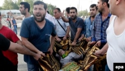 People help wounded victims after an explosion during a election campaign rally for the Peoples' Democratic Party (HDP) in southeastern Turkey.