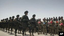 Afghan troops pass by Italian soldiers from the NATO-led International Security Assistance Force (ISAF) during the transfer of authority to Afghan security forces in Herat last July.
