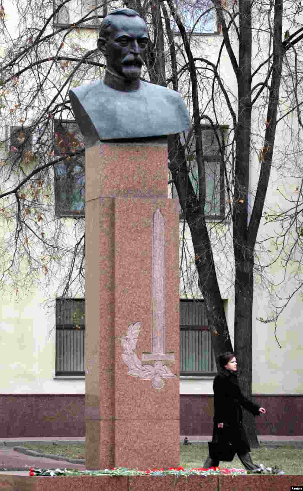 A woman walks under a Dzerzhinsky monument that was reinstalled in a courtyard of the Moscow police headquarters, in 2005.