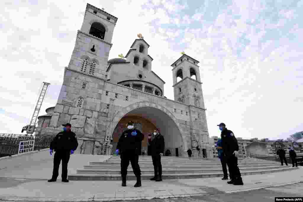 Police officers watch the entrance of the Cathedral of the Resurrection of Christ in Podgorica, Montenegro, on April 19 as Serbian Orthodox priests hold a morning Easter liturgy without worshipers.
