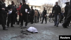 Policemen gather evidence at a bomb blast site in Tehran, which killed nuclear scientist Mostafa Ahmadi Roshan on January 11.