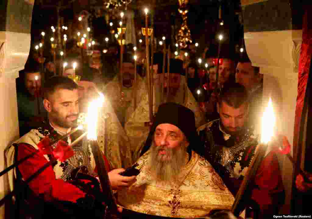 Archimandrite Partenie attends Orthodox Easter services at St. John the Baptist Monastery near Mavroro, North Macedonia, as the service is streamed online on April 18.