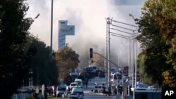 Smoke rises as emergency response teams and police officers attend the scene of an explosion at Turkish Aerospace Industries Inc. on the outskirts of Ankara on October 23.