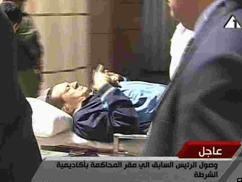 Mubarak məhkəməyə xəstəxana çarpayısında çıxarlır, dəmir barmaqlıq arxasında ifadə verir. 15 avqust 2011