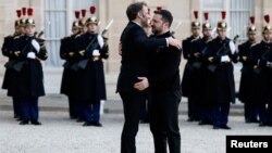 Președintele francez Emmanuel Macron și președintele ucrainean Volodimir Zelenski se îmbrățișează în timp ce se întâlnesc pentru o întâlnire înaintea conferinței de joi de la Paris. REUTERS/Benoit Tessier