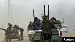 Rebel fighters flee from Ajdabiya on the road to Benghazi on March 15.