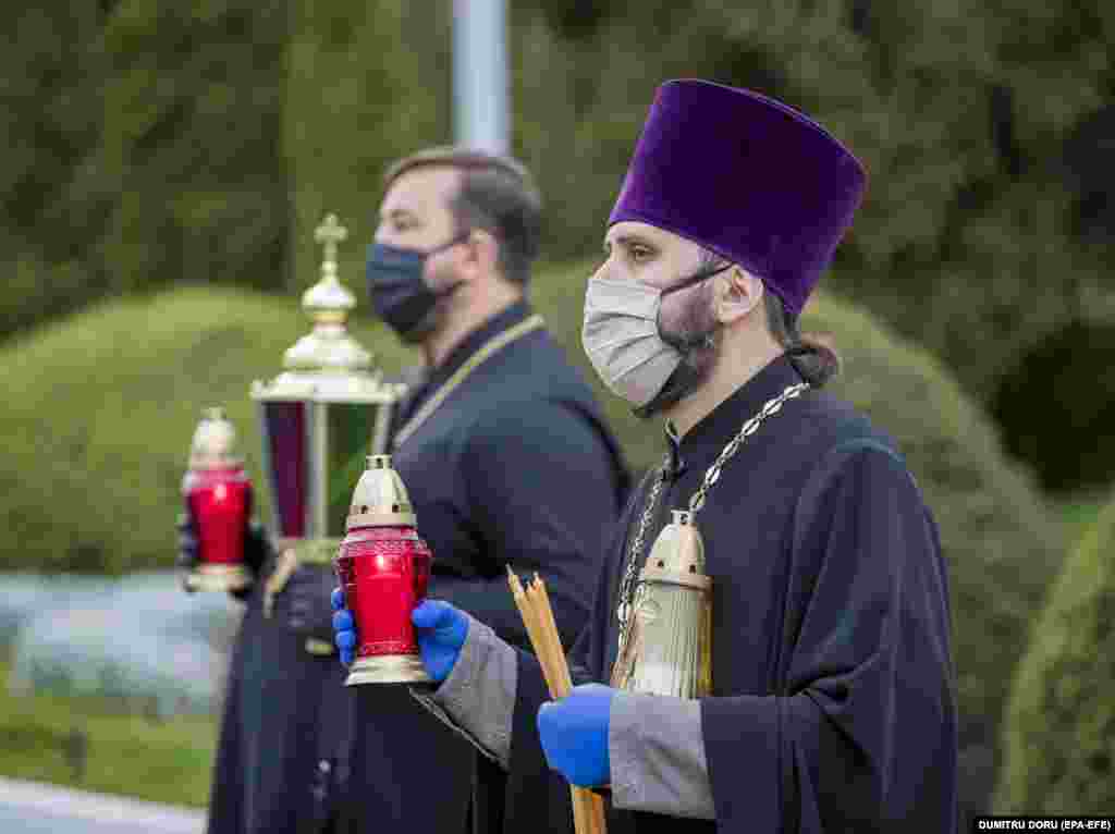 Priests hold the Holy Fire from Jerusalem before the Orthodox Easter celebrations at Chisinau International Airport, Moldova, on April 18.