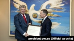 Президент України Петро Порошенко (ліворуч) і спецпредставник Сполучених Штатів Курт Волкер, який вручив керівнику Української держави символічну копію декларації від 25 липня 2018 року, в якій чітко зафіксована позиція США щодо невизнання незаконної анексії Росією українського Криму. Нью-Йорк, 25 вересня 2018 року
