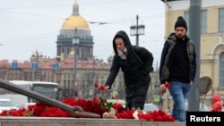 People in central Saint Petersburg lay flowers at a makeshift memorial to the victims of a shooting incident at a concert hall outside Moscow the previous day.