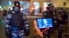 Freedom House upozorava na prelivanje represivnih mehanizama iz država sa niskim demokratskim standardima, između ostalih i u Rusiji. Na slici učesnik protesta u Moskvi pokazuje fotografiju Navaljnog, naspram policajaca pred sukobe 2. februara 2021. 