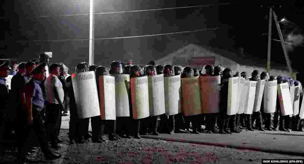 Riot police in formation during the raid. The authorities have since withdrawn from the village. 