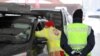 A medic checks the temperature of a driver coming from Italy due to the spread of the coronavirus disease