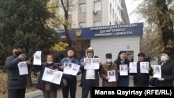 Активисты с плакатами с изображениями погибших при загадочных обстоятельствах политиков и журналистов перед зданием департамента полиции города Алматы. 11 ноября 2020 года.