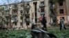 Місцеві жителі проходять повз житлового будинку, пошкодженого російським авіаударом у Харкові, Україна, 5 травня 2024 року. Фото ілюстративне