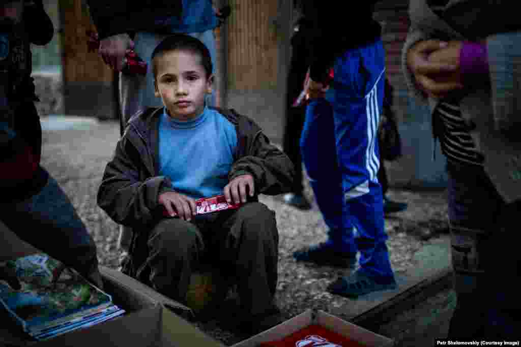 A young refugee boy unwraps chocolate distributed by volunteers in accommodation for displaced Ukrainians in Donetsk. Despite the truce between the separatists and Ukrainian government forces, there is still sporadic fighting. Refugees from shelled areas have sheltered inside Donetsk University campus buildings.