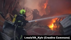 Pompierii lucrează la locul unde se află o clădire de birouri lovită de o rachetă rusească la Kiev, la începutul zilei de 6 aprilie 2025.