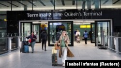 În imagine, pasageri care trec pe la unul din terminalurile aeroportului Heathrow, sâmbătă, la o zi după ce actiivitatea aeroportului a fost sistată vineri, ca urmare a unui incendiu la o substație care asigura alimentarea cu electricitate.