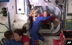 Эл аралык космос бекетиндеги астронавттар SpaceX кемесинин астронавттарын кабыл алууда. 2020-жылдын 17-ноябры.
