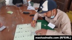 پخوانی تصویر: د رايو اچولو په مرکز کې يو څارونکی افسر د يو تن د شناختي کارډ معلومات ثبتوي