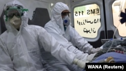 Emergency medical staff transferring a patient with COVID-19 to a Tehran hospital on March 30.