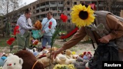 Ljudi ostavljaju igračke i cveće na igralište u gradu Krivi Rih gde je ruskom napadu ubijeno devet dece, 5. april 2025.