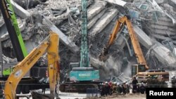 În Bangkok, echipe de salvare dotate cu utilaje grele încearcă să găsească supraviețuitori în dărâmăturile unui bloc turn care a căzut în timpul cutremurului.