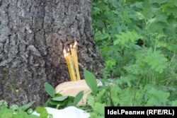 Candles burn in a loaf of bread left as an offering during the ceremony.