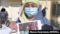 Этническая казашка Алмахан Мырзан перед китайским консульством в Алматы держит фото своего брата, задержанного и заключённого под стражу в Синцьзяне. 26 февраля 2021 года