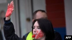 Ръката и бузите на млада жена на протестите в Сърбия са боядисани в червено като символ на насилието, упражнено над протестиращи. Масовото гражданско недоволство започна заради срутена козирка на гарата в Нови Сад, която причини смъртта на 15 души. Белград, 28 януари 2025 г.