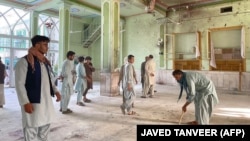 Afghan men inspect the damage at a Shi'ite mosque in Kandahar on October 15 after a suicide bombing during Friday Prayers.