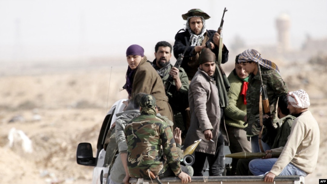 Rebel forces ride on the back of a pick-up truck in Ajdabiya, Libya, on March 2.