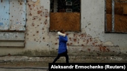 A woman walks past a store damaged by shelling in the separatist-held city of Donetsk in eastern Ukraine. (file photo)