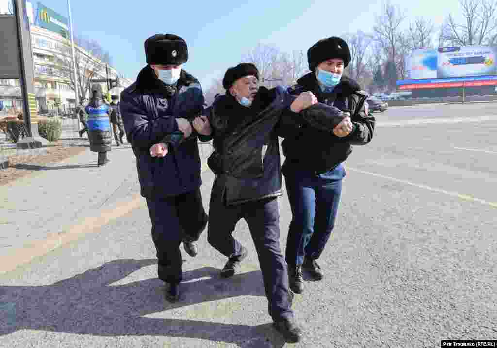 Police detain a protester in Almaty.