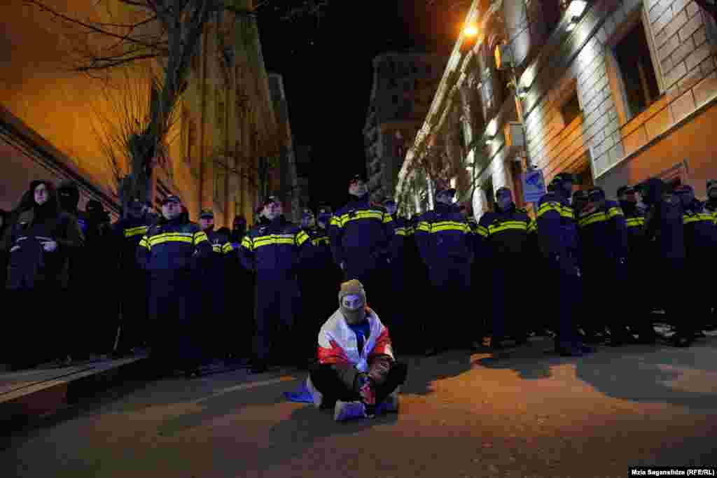 Demonstrant u Tbilisiju sedi tokom protesta zbog rezultata kontroverznih parlamentarnih izbora prošlog meseca, 24. novembra 2024.