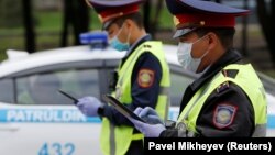 Сотрудники дорожной полиции на пропускном посту в Алматы.