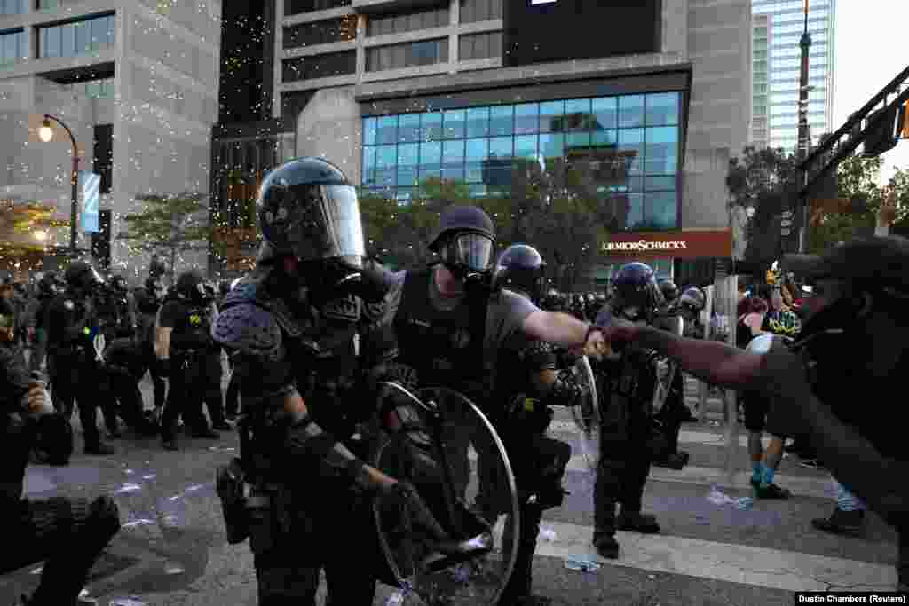 Pripadnik policije i prosvjednik izvode "pozdrav pesnicama" (fist-bump) tijekom policijskog sučeljavanja s prosvjednicima u Atlanti, Georgia, 1. lipnja.