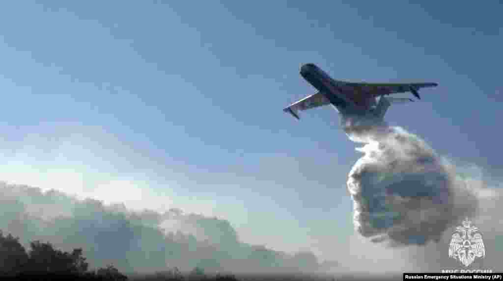 Another Beriev Be-200 aircraft drops its load of water.