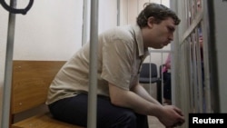 Михаил Косенко «Болотное иши» боюнча сотто баш коргоо чарасын кароо учурунда. 2013-жылдын майы. Кийин Михаил психиатриялык мажбур дарылоого жөнөтүлгөн. Сүрөт: Reuters.