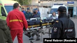 Medics transport injured people outside a hospital following an attack on a local college in the city of Kerch, Crimea, on October 18.