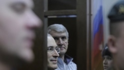 Mikhail Khodorkovsky and Platon Lebedev (center, left and right) look on from the dock of a Moscow courtroom on December 30.