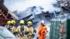 Pompierii olandezi lângă ruinele fumegânde după stingerea incendiului, la Haga, pe 7 decembrie.