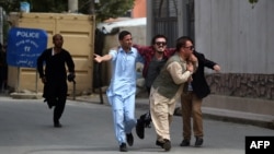 Supporters of Afghan Vice President Abdul Rashid Dostum carry a wounded colleague during clashes at the reburial of Habibullah Kalakani, a controversial Afghan monarch who died in 1929.