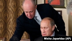 Російський бізнесмен, «кухар Путіна» Євген Пригожин (ліворуч) у своєму ресторані подає їжу тодішньому прем’єр-міністрові Володимиру Путіну, 11 листопада 2011 року
